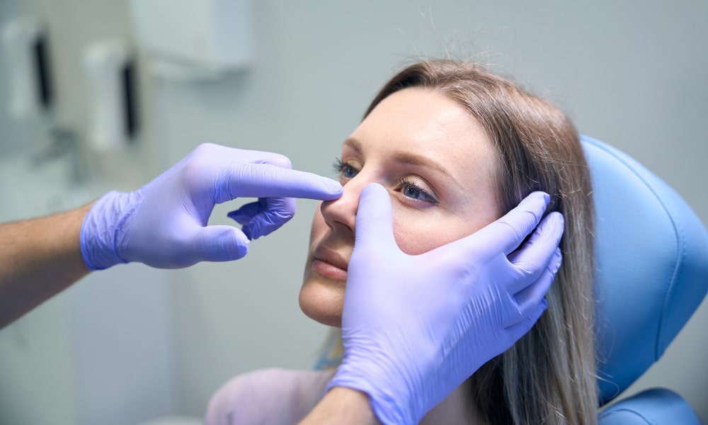 Patient undergoing nasal examination before thick-skin rhinoplasty surgery