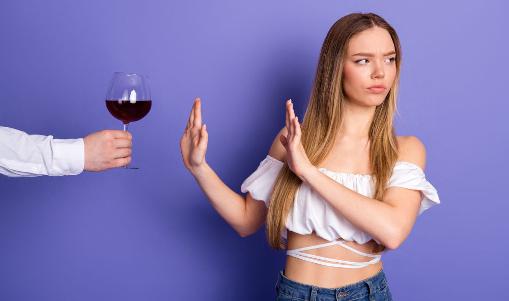 Avoid Alcohol After Rhinoplasty to Reduce Swelling Woman declining a glass of wine — avoiding alcohol helps reduce swelling and bruising after rhinoplasty.