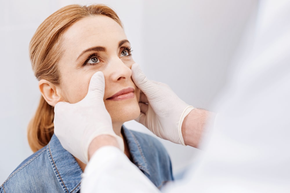 Woman consulting with a facial plastic surgeon about revision rhinoplasty in Toronto Patient at consultation with plastic surgeon before revision rhinoplasty